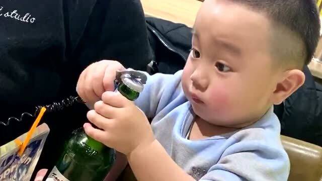 萌娃帮爸爸开酒瓶子盖,全部力气都用到了表情上,开完还不忘比赞