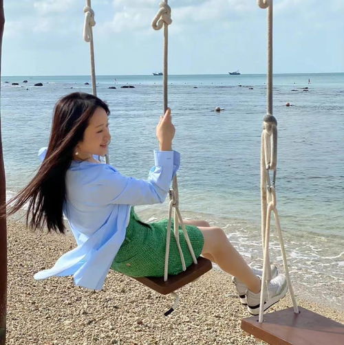50岁杨钰莹海边度假太惬意,翘腿荡秋千玩心十足,黑发浓密若冻龄